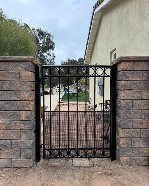 Wrought iron gate with stone pillars