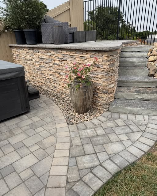 Paver patio with stacked stone seat wall and bluestone steps