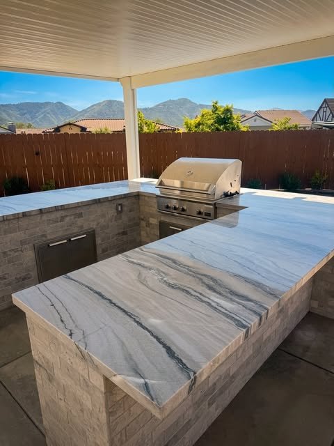 Outdoor kitchen with granite countertop and built-in grill