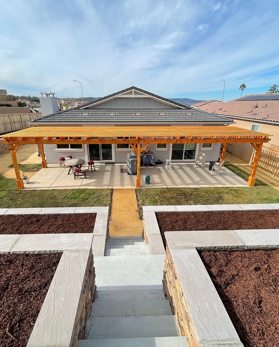 Paver patio, stairs and concrete work beneath a custom pergola